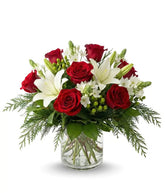 Bouquet of red roses and white lilies in a clear vase on a white background
