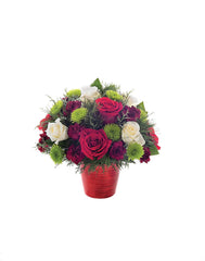 Bouquet of red, white, and green flowers in a red vase on a white background